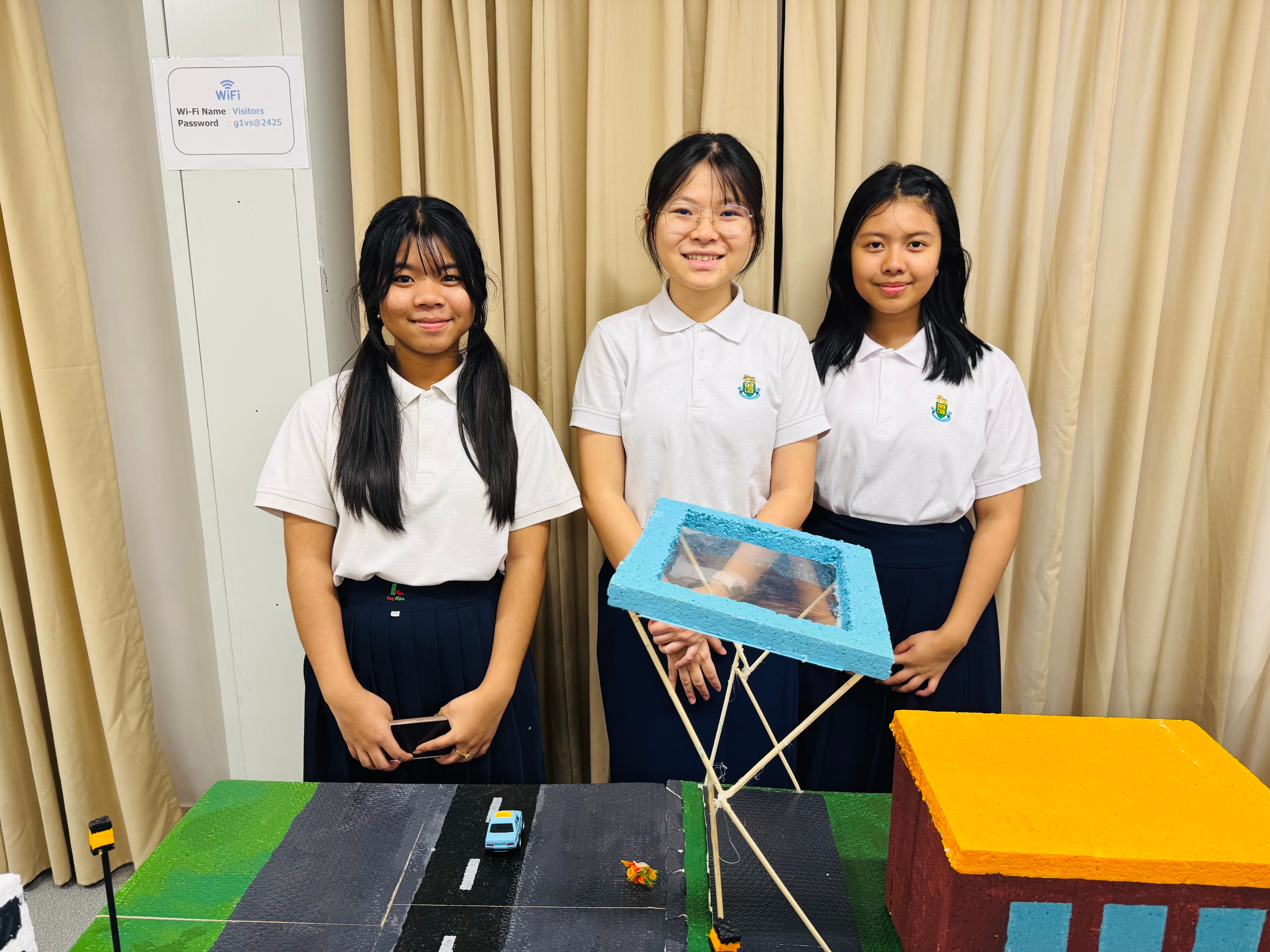 Team AIdealists - San San, May Thet Hlaing Kyaw, and Thune Nay Aww with their WRO project setup